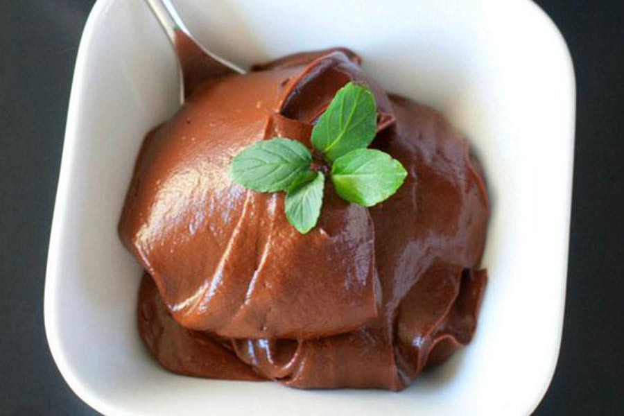 Dish of velvety chocolate mousse, garnished with a mint sprig